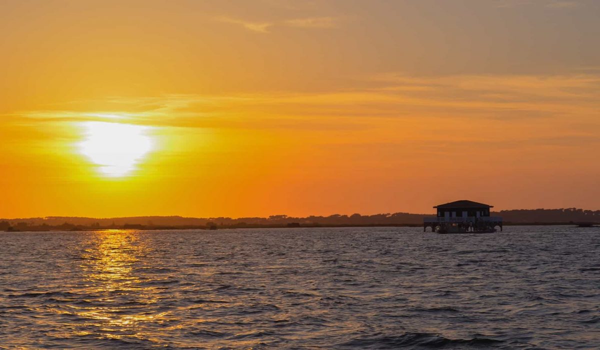 Photo d'un coucher de soleil éclatant derrière les cabanes Tchanquées