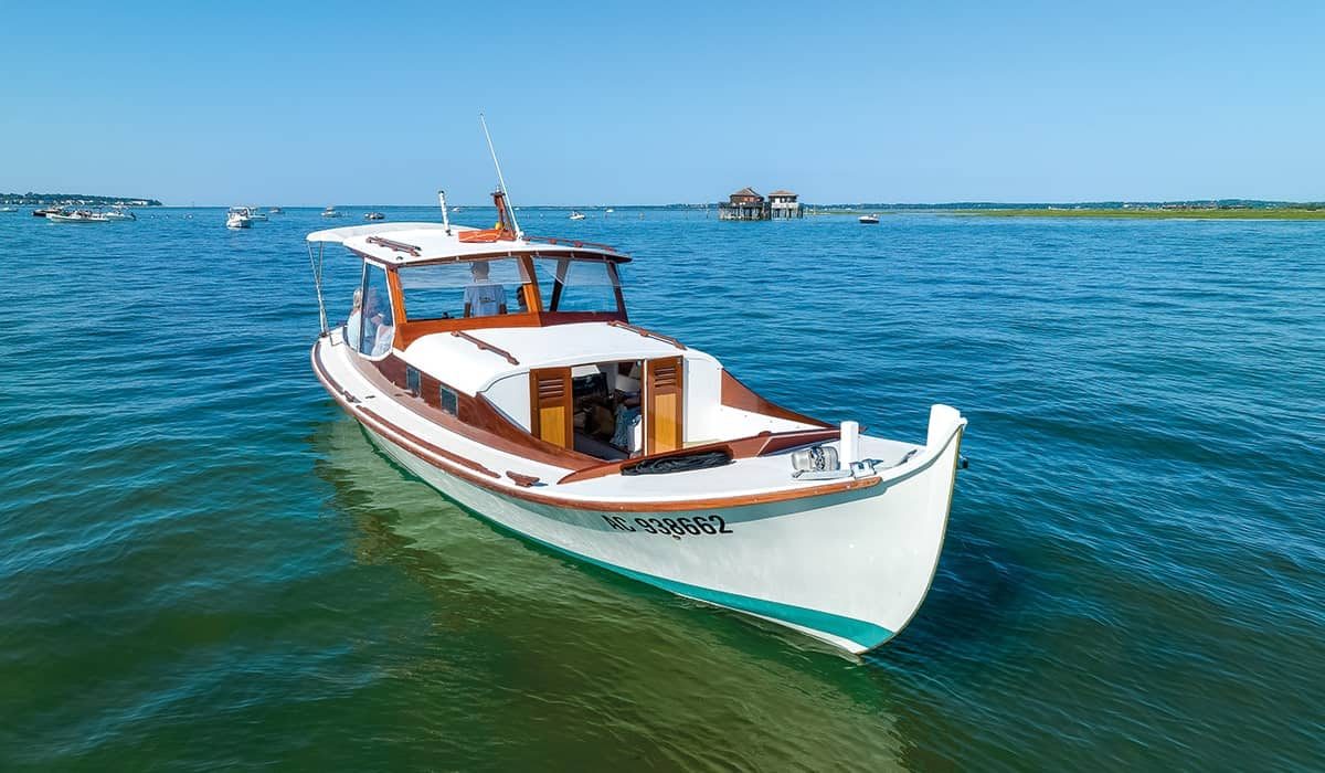 Vue pittoresque de la pinasse Ohana et des cabanes tchanquées de l’île aux Oiseaux sur le bassin d’Arcachon