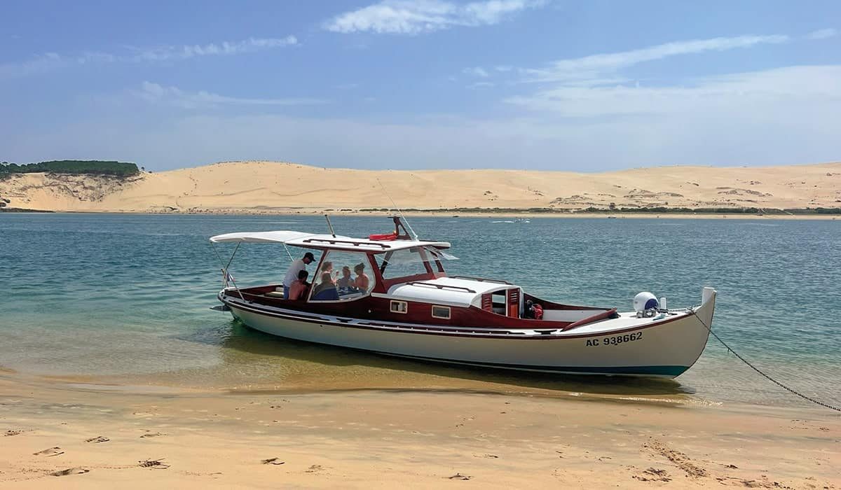 La pinasse Ohana sur le Banc d'Arguin avec en toile de fond la Dune du Pilat