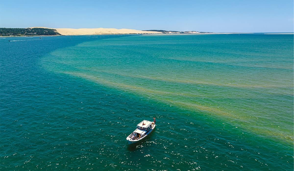 La pinasse Ohana navigue devant la majestueuse Dune du Pilat